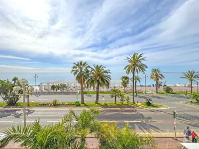 an empty street with palm trees and a building at PROMENADE HOLIDAY - ROYAL LUXEMBOURG PROMENADE in Nice
