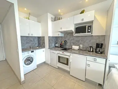 a kitchen with white cabinets and a washer and dryer at PROMENADE HOLIDAY - ROYAL LUXEMBOURG PROMENADE in Nice