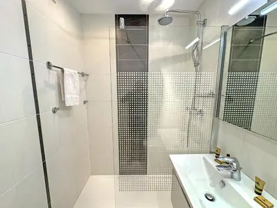 a white bathroom with a shower and a sink at PROMENADE HOLIDAY - ROYAL LUXEMBOURG PROMENADE in Nice
