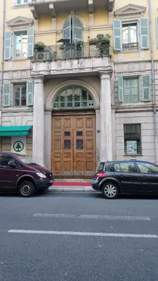 two cars parked in front of a building with a wooden door at Sam Le Lezard Sarl in Nice