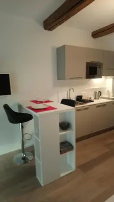 a kitchen with a white counter and a stool at Sam Le Lezard Sarl in Nice