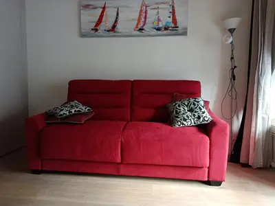 a red couch with two pillows on it in a living room at Sam Le Lezard Sarl in Nice