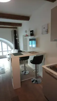 a kitchen with a desk and two bar stools at Sam Le Lezard Sarl in Nice