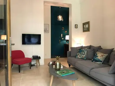a living room with a couch and a red chair at Homelivia, Luxueux Appartement avec Jardin privé in Nice