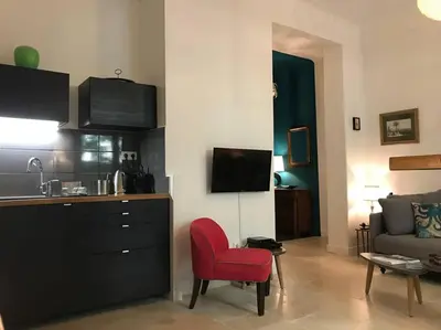 a living room with a red chair and a couch at Homelivia, Luxueux Appartement avec Jardin privé in Nice