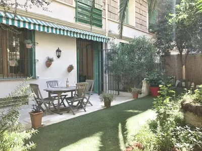 a patio with a table and chairs in a yard at Homelivia, Luxueux Appartement avec Jardin privé in Nice