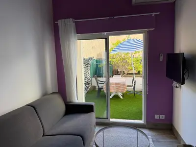 a living room with a couch and an umbrella at Nice Sunshine in Nice