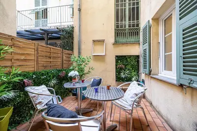 a patio with two tables and chairs on a balcony at Large one bedroom flat in the Old Town in Nice