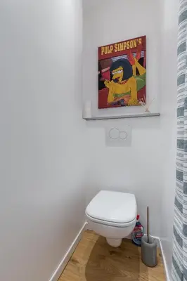 a bathroom with a toilet and a poster on the wall at Large one bedroom flat in the Old Town in Nice