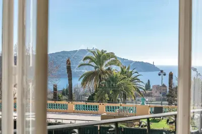 a view of the ocean and palm trees from a balcony at Semiramis in Villefranche-sur-Mer