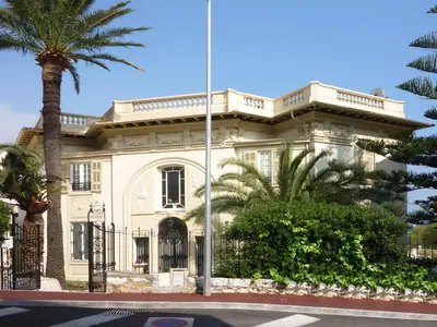 a white house with a palm tree in front of it at Semiramis in Villefranche-sur-Mer