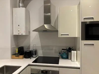 a kitchen with white cabinets and a stove top oven at Nice Port, French Riviera in Nice