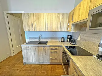 a kitchen with wooden cabinets and a sink at PROMENADE HOLIDAY - ROCAMARE PROMENADE in Nice