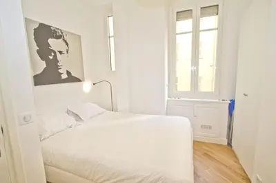 a white bedroom with a bed and a window at PROMENADE HOLIDAY - SOLEMAR PROMENADE in Nice