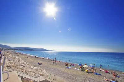 a group of people on a beach with the ocean at PROMENADE HOLIDAY - SOLEMAR PROMENADE in Nice