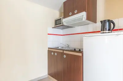 a small kitchen with a sink and a refrigerator at Appart'City Classic Nice Acropolis in Nice
