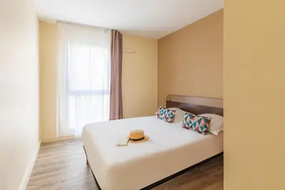 a bedroom with a bed with a hat on it at Appart'City Classic Nice Acropolis in Nice
