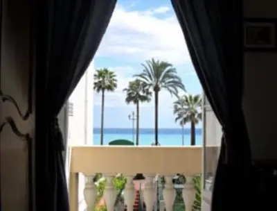 a window with a view of the ocean and palm trees at Villa Eden in Nice