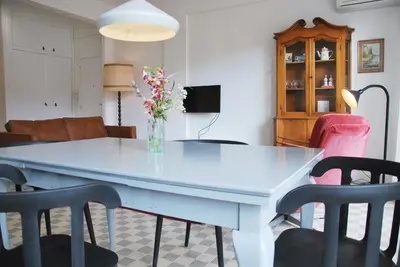 a white dining room table with chairs and a vase of flowers at Les Gérardines by EnjoyNice, 3-room with Airco and balcony in Nice