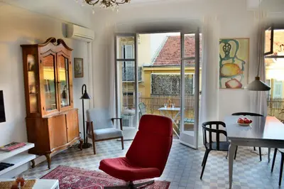 a living room with a red chair and a table at Les Gérardines by EnjoyNice, 3-room with Airco and balcony in Nice
