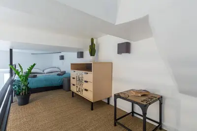 a kitchen with a dining room table with chairs and a tableasteryasteryasteryastery at ANGLE DROIT- LOFT CHARMANT ET ATYPIQUE, CLIMATISATION, Vieux-Nice in Nice