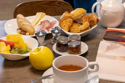 a table with plates of food and a cup of coffee at Hotel 66 Nice in Nice
