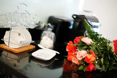 a table with a bouquet of flowers and a phone at Sea view luxury apartment in Saint-Laurent-du-Var