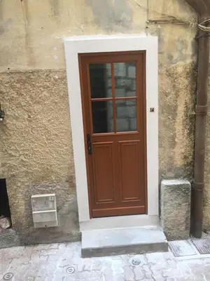 a brown door on the side of a building at Le Noble in Scenic Villefranche Sur Mer in Villefranche-sur-Mer