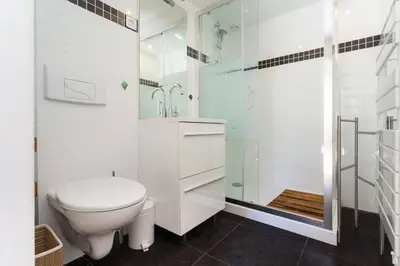 a white bathroom with a toilet and a shower at Le Noble in Scenic Villefranche Sur Mer in Villefranche-sur-Mer