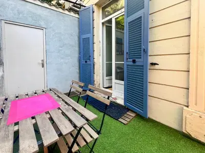 a picnic table and bench outside of a house at Proche promenade des anglais et de la mer in Nice