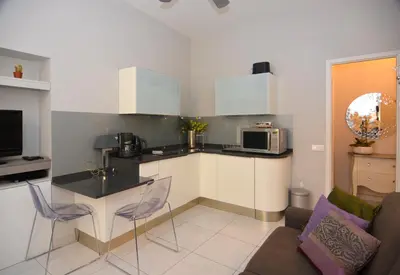 a kitchen with a table and chairs in a room at Je suis à Nice in Nice
