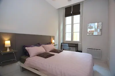 a bedroom with a large bed with pink pillows at Je suis à Nice in Nice