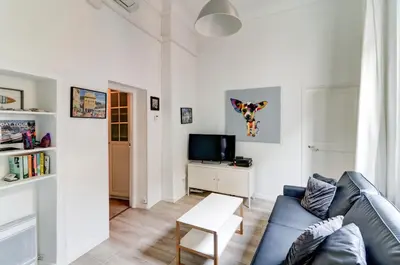 a living room with a blue couch and a tv at Lovely Cosy Flat in Nice old town in Nice