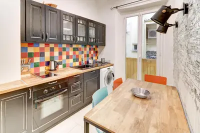 a kitchen with a table and a sink and a dishwasher at Lovely Cosy Flat in Nice old town in Nice