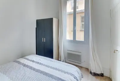 a bedroom with a bed and a cabinet and a window at Lovely Cosy Flat in Nice old town in Nice