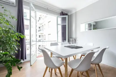 a white dining room with a white table and chairs at Ultra Central Large 2 Bdr near Massena Square in Nice