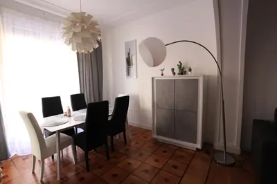 a dining room with a table and chairs and a lamp at Seaflat in Nice in Nice