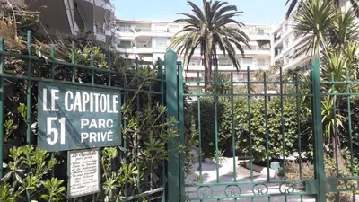a green fence with a sign on it at Seaflat in Nice in Nice