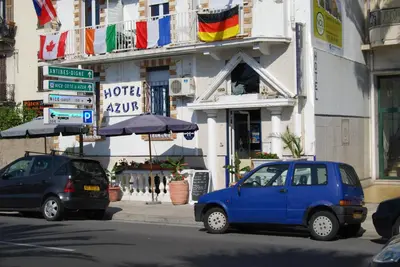 a small blue car parked in front of a building at Hôtel Azur in Nice