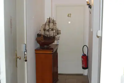 a model ship on top of a dresser in a hallway at Hôtel Azur in Nice