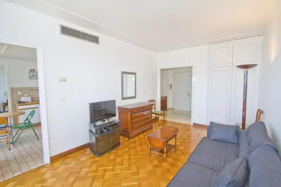 a living room with a blue couch and a television at PROMENADE HOLIDAY - ORIENT & SEA in Nice