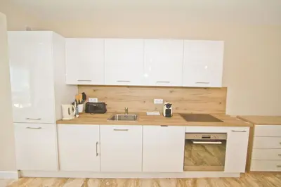 a kitchen with white cabinets and a sink at PROMENADE HOLIDAY - COSY SEA FRONT STUDIO in Nice