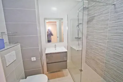 a person taking a picture of a bathroom with a shower at PROMENADE HOLIDAY - COSY SEA FRONT STUDIO in Nice