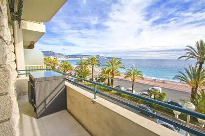 a balcony with a view of the ocean and palm trees at PROMENADE HOLIDAY - AZUR PROMENADE in Nice
