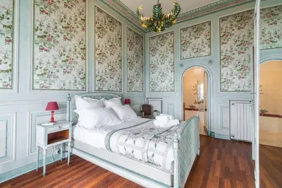 a bedroom with a bed with floral wallpaper at Villa COLLIN - Promenade des Anglais in Nice