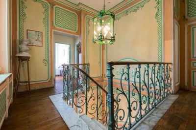 an ornate staircase in a home with a chandelier at Villa COLLIN - Promenade des Anglais in Nice