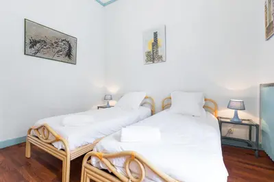 two twin beds in a room with white walls at Villa COLLIN - Promenade des Anglais in Nice