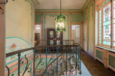 an ornate staircase in a home with a chandelier at Villa COLLIN - Promenade des Anglais in Nice