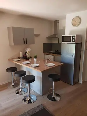 a kitchen with a island with bar stools in it at Les Palmiers à 700m de la mer in Nice