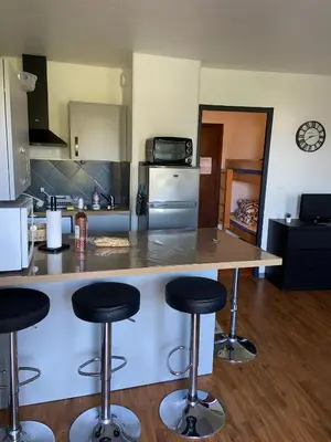 a kitchen with a counter and bar stools at Les Palmiers à 700m de la mer in Nice